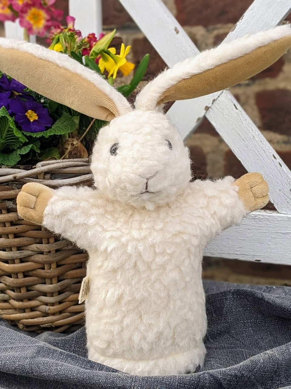 Handpuppe Hase von vorne vor Blumen Handpuppe Hase von vorne vor Blumen