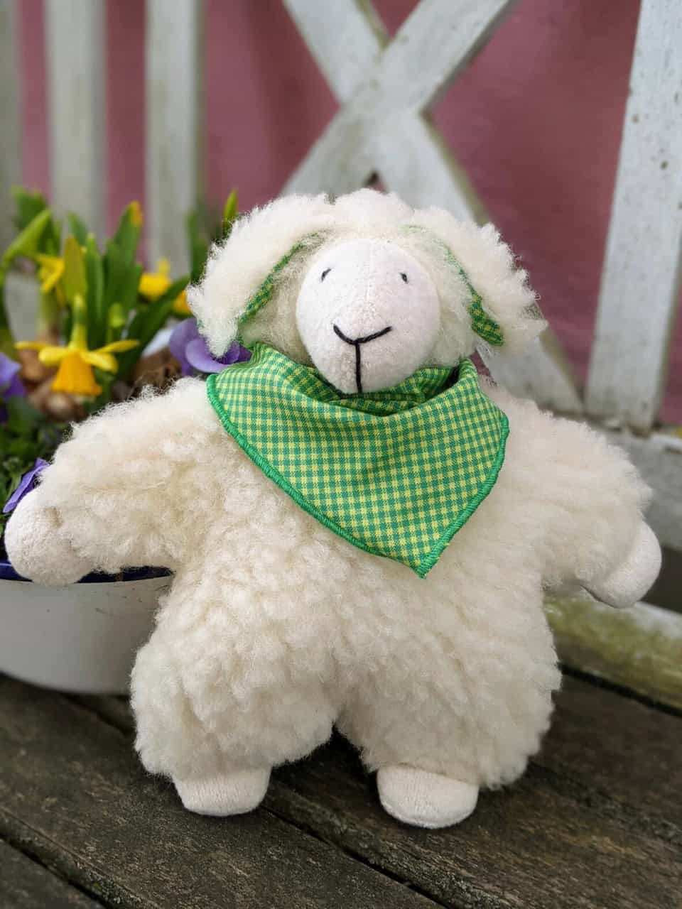 Kirschkernkissen Schaf Hugo von vorne vor Blumen Kirschkernkissen Schaf Hugo von vorne vor Blumen