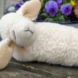 Schaf Kuscheltier Lotti vor Blumen