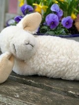 Schaf Kuscheltier Lotti vor Blumen